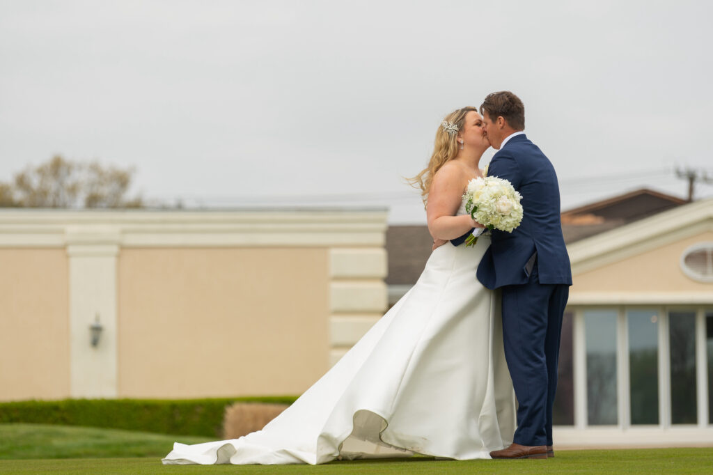 Bride and groom kissing at Lawrence Yacht Club