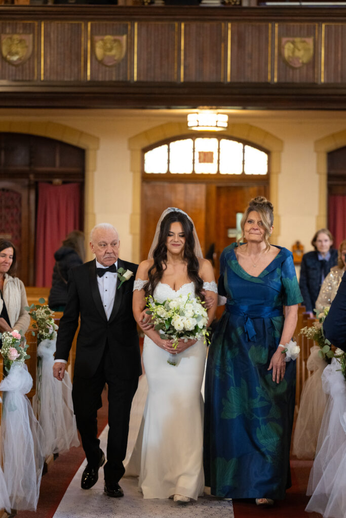 Bride and her parents walking down the aisle at church