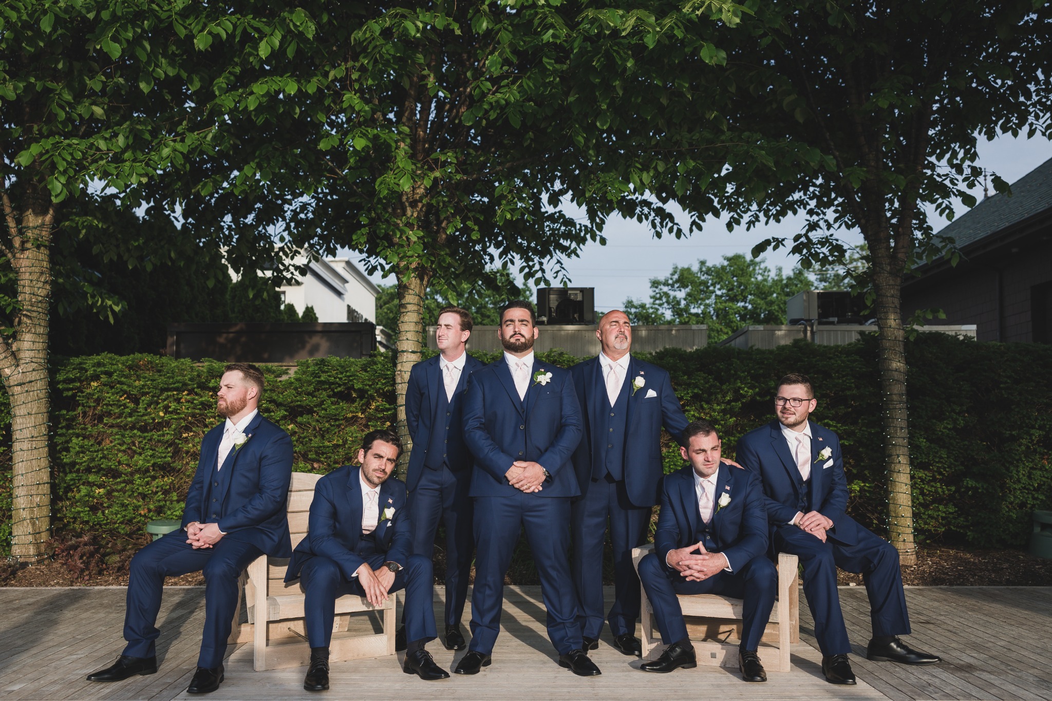 Groom and groomsmen wearing matching navy suits outdoors